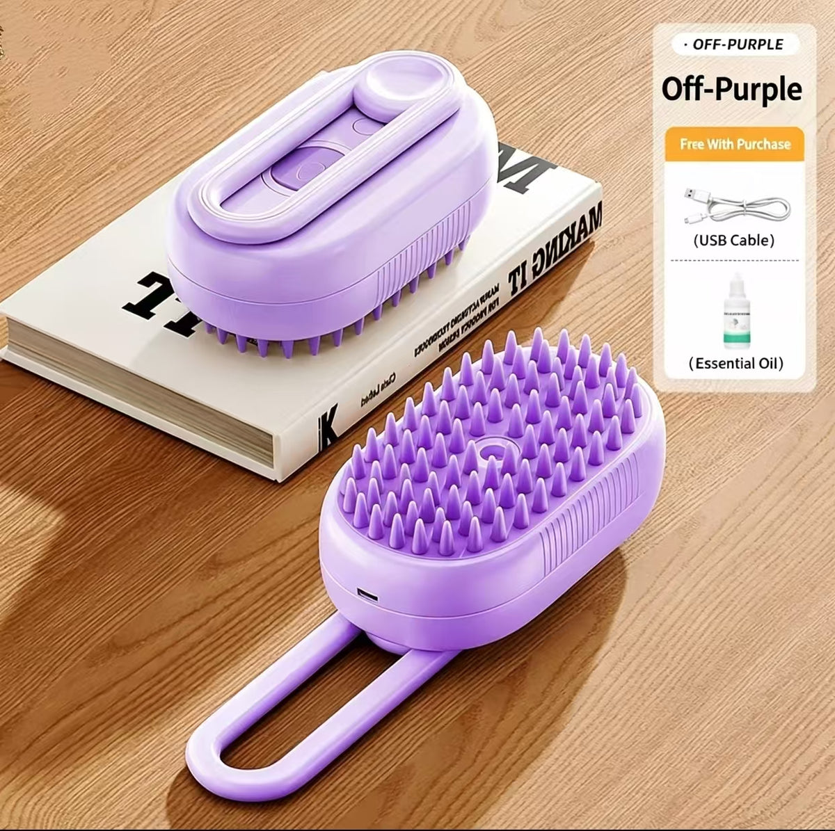 Two lavender pet grooming brushes arranged on a wooden surface, with one brush resting on a book and the other in the foreground. A promotional panel on the right reads 'Off-Purple' and lists a USB cable and essential oil included with purchase.